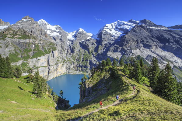 Hikers around Lake  Oeschinensee Bernese Oberland Kandersteg Canton of Bern Switzerland Europe