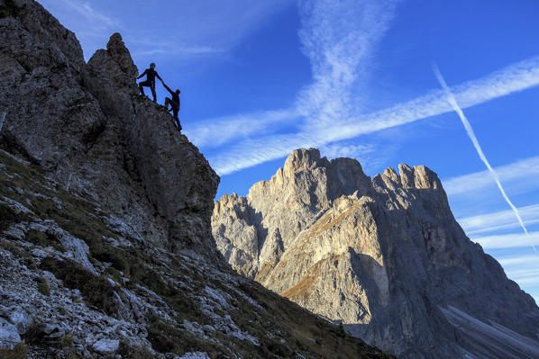 Hikers climb rocks to admire peaks Furcella De Furcia Odle Funes Valley South Tyrol Dolomites Trentino Alto Adige Italy Europe