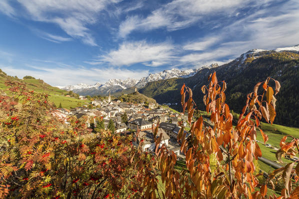 Autumn colors frame the village of Ardez surrounded by woods and snowy peaks Engadine Canton of Graubünden Switzerland Europe