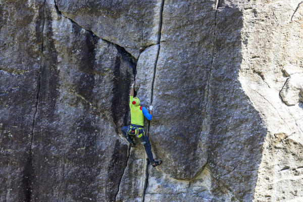 The climber faces the steep climb of Sasso Remenno Masino Valtellina Lombardy Italy Europe