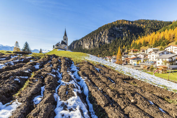 The church of Schmitten surrounded by colorful woods and snow Albula District Canton of Graubünden Switzerland Europe
