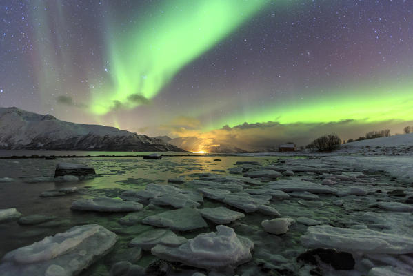 The Northern Lights illuminates the icy landscape in Svensby Lyngen Alps Tromsø Lapland Norway Europe