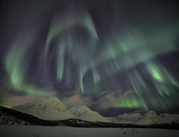 The Northern Lights illuminates the snowy landscape in Svensby Lyngen Alps Tromsø Lapland Norway Europe