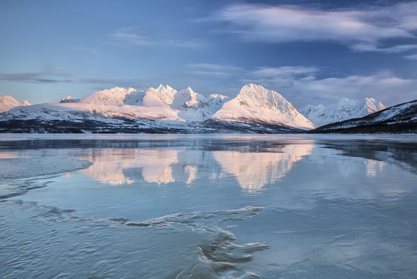 Blue sky and snowy peaks are reflected in the frozen Lake Jaegervatnet Stortind
Lyngen Alps Tromsø Lapland Norway Europe