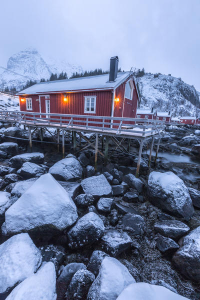 Typical fishermen houses called rorbu in the  snowy landscape at dusk Nusfjord Nordland County Lofoten Islands Norway Europe