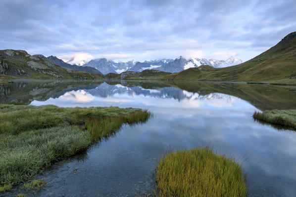 The mountain range is reflected in Fenetre Lakes at dusk Ferret Valley Saint Rhémy Grand St Bernard Aosta Valley Italy Europe