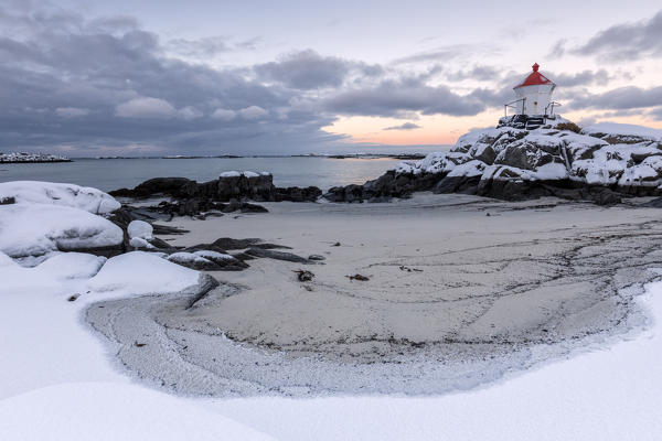 Colorful arctic sunset on the lighthouse surrounded by snow and icy sand Eggum Vestvagoy Island Lofoten Islands Norway Europe