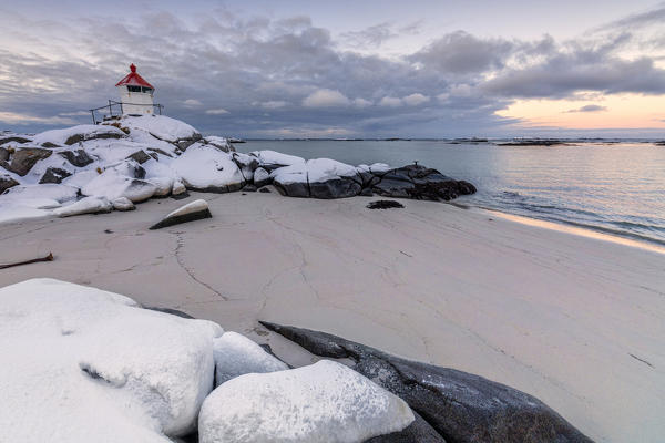 Colorful arctic sunset on the lighthouse surrounded by snow and icy sand Eggum Vestvagoy Island Lofoten Islands Norway Europe