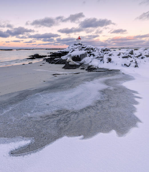 Colorful arctic sunset on the lighthouse surrounded by ice and snow Eggum Vestvagoy Island Lofoten Islands Norway Europe