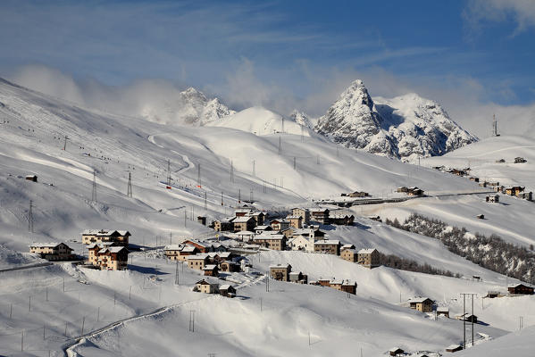 View of Trepalle village the highest town in Italy in winter with the tops of Livigno Valley windswept. Valtellina. Lombardy Italy Europe