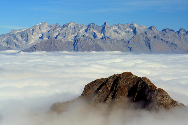 View from Mount Azzarini of a carpet of clouds that covers the lower Valtellina during autumn. San Marco Pass. Albaredo. Bitto Valley. Lombardy. Italy Europe