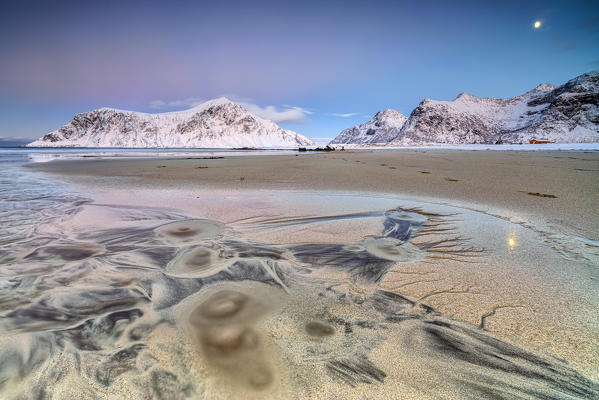 Full Moon reflected on sand in the surreal scenery of Skagsanden beach Flakstad Nordland county Lofoten Islands Norway Europe