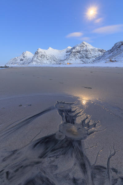 Full Moon reflected on the sand around the surreal Skagsanden beach Flakstad Nordland county Lofoten Islands Norway Europe