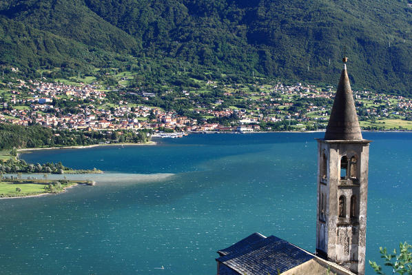 The church tower of Montemezzo overlooking Lake Como. In the background Colico the last town on the eastern shore of Lario. Lombardy. Italy. Europe