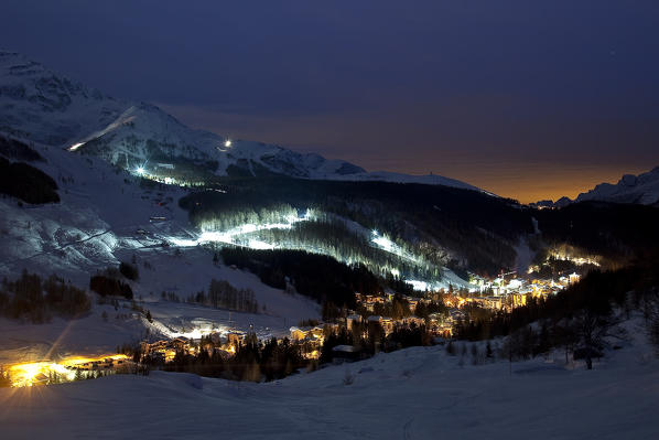 Madesimo and its ski slopes lit during a full moon night. Valchiavenna. Vallespluga. Valtellina. Lombardy. Italy. Europe 