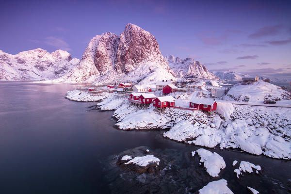 The colors of dawn on snowy peaks and the frozen sea around the fishing village Hamnoy Nordland Lofoten Islands Norway Europe