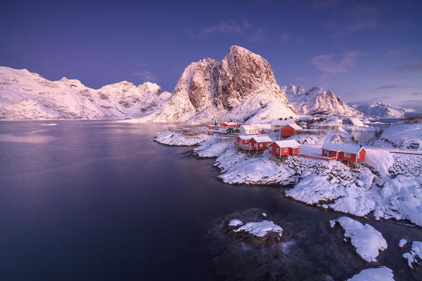 The colors of dawn on snowy peaks and the frozen sea around the fishing village Hamnoy Nordland Lofoten Islands Norway Europe