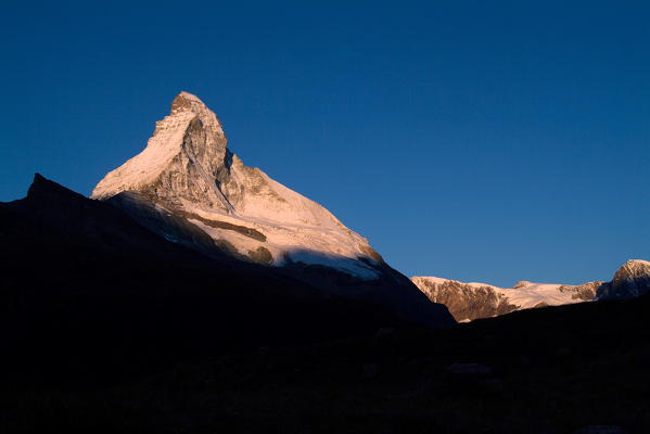 The wonderful pyramid of the snow-capped summit of the Matterhorn at sunrise, seen from the valley of Zermatt in the Canton of Valais in Switzerland Europe