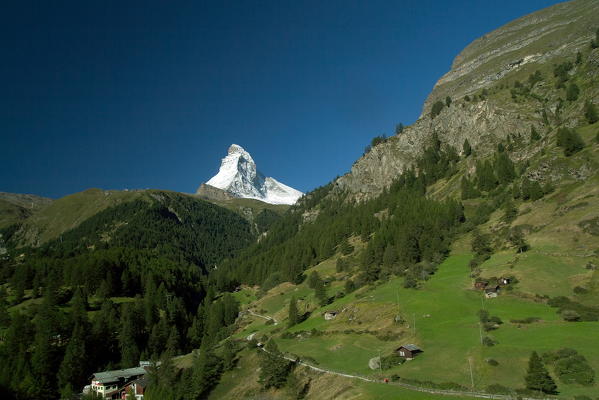 The wonderful pyramid of the snow-capped summit of the Matterhorn contrasting with the green of the valley of Zermatt in the Canton of Valais in Switzerland Europe