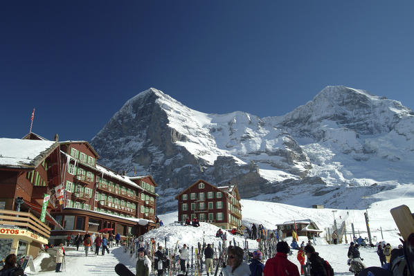 Skiers at the Kleine-Scheidegg station right below the awesome walls of the Eiger and the Monch in the Bernese Alps, Switzerland Europe