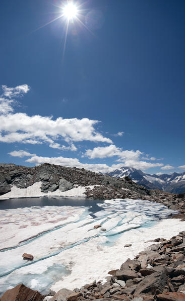 The little lake of Entova in Valmalenco is often frozen even in summer because of its high altitude, in the background you can see Mount Disgrazia, Lombardy Italy. Europe