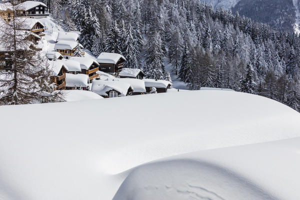 The snowy woods frame the typical mountain huts Bettmeralp district of Raron canton of Valais Switzerland Europe