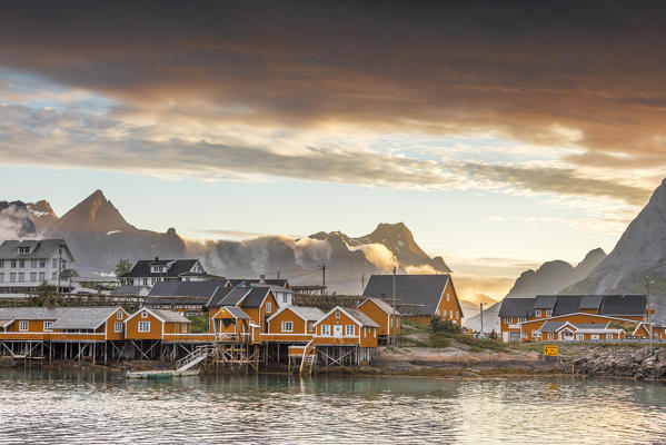 Sunset on the fishing village frames by rocky peaks and sea Sakrisoya Nordland county Lofoten Islands Northern Norway Europe