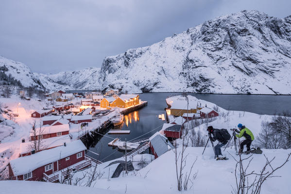 Photographers at dusk close to the fishing village covered with snow Nusfjord Nordland Lofoten Islands Northern Norway Europe