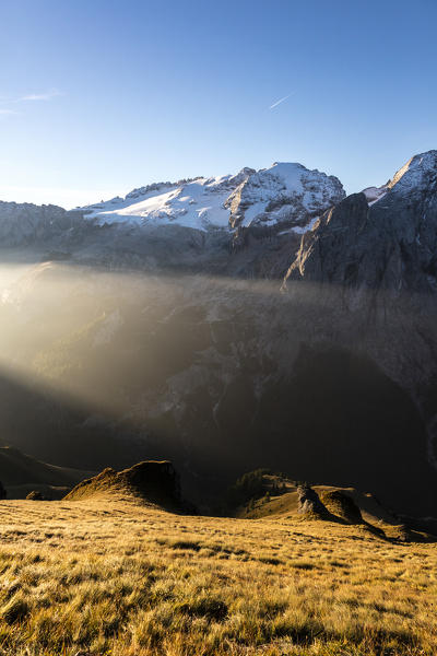 Blue sky and light beam frame the snowy peaks of Marmolada at dawn Cima Belvedere Val di Fassa Trentino Alto Adige Italy Europe