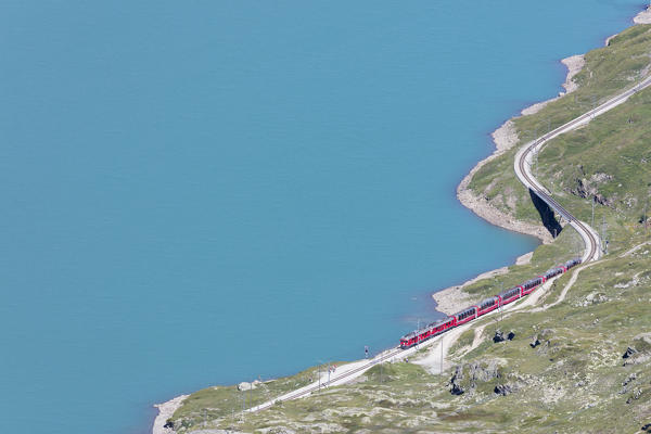 The Bernina Express train passes on the shores of Lago Bianco Bernina Pass Canton of Graubünden Engadine Switzerland Europe