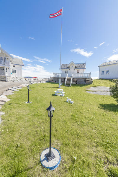 The summer blue sky frames the green gardens and typical houses Sakrisoy Nordland county Lofoten Islands Northern Norway Europe