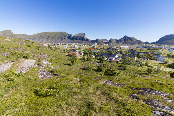 Green meadows frame the village of Sorland surrounded by sea Vaeroy Island Nordland county Lofoten archipelago Norway Europe