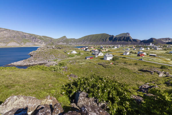 Green meadows frame the village of Sorland surrounded by sea Vaeroy Island Nordland county Lofoten archipelago Norway Europe