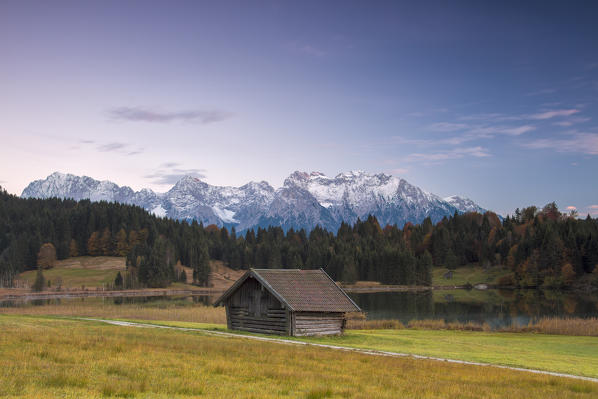 Wooden hut frames the alpine lake surrounded by the Alps Geroldsee Krün Garmisch Partenkirchen Upper Bavaria Germany Europe