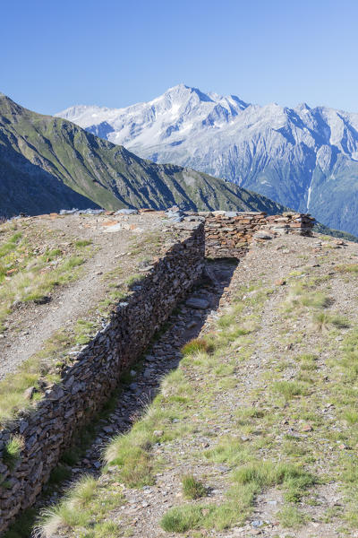 A stone path framed by rocky peaks and blue sky Forcellina Di Montozzo Camonica Valley province of Brescia Lombardy Italy Europe