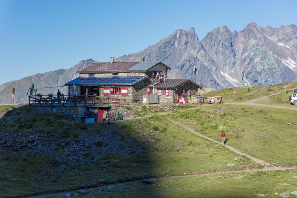 View of Rifugio Bozzi framed by rocky peaks and meadows Val Di Viso Camonica Valley province of Brescia Lombardy Italy Europe