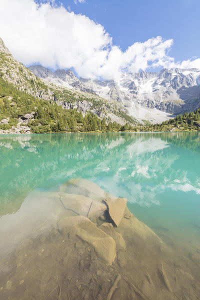 Rocky peaks and woods are reflected in Aviolo Lake Vezza D'Oglio Camonica Valley province of Brescia Lombardy Italy Europe