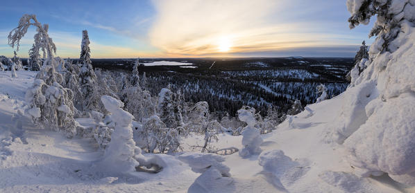 Panorama of snowy landscape and woods framed by blue sky and sun Ruka Kuusamo Ostrobothnia region Lapland Finland Europe