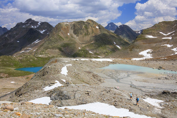 Hikers among turquoise lakes and rocky peaks in summer Joriseen Jörifless Pass canton of Graubünden Engadin Switzerland Europe