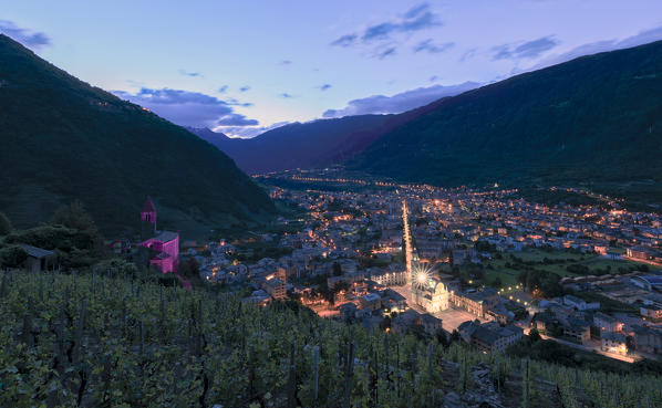 Ancient Xenodochio of Santa Perpetua and the illuminated town of Tirano, province of Sondrio, Valtellina Lombardy, Italy, Europe