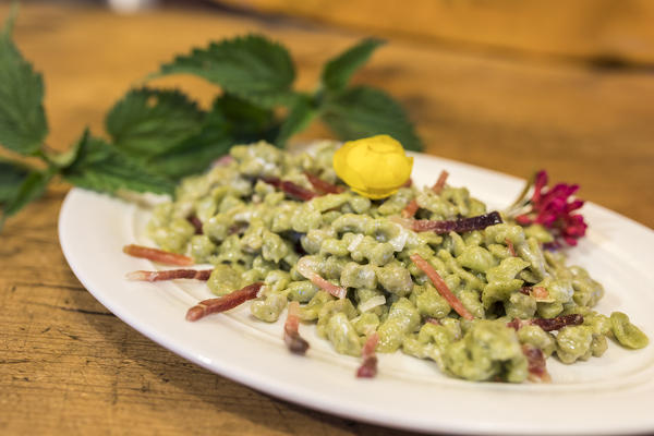 Plate of gnocchi with cheese and cured meat, San Romerio Alp, Brusio, Canton of Graubünden, Poschiavo valley, Switzerland