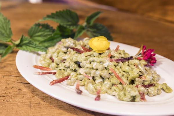 Plate of gnocchi with cheese and cured meat, San Romerio Alp, Brusio, Canton of Graubünden, Poschiavo valley, Switzerland