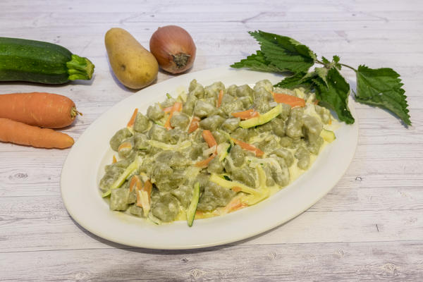 Plate of gnocchi with vegetables and cheese, San Romerio Alp, Brusio, Canton of Graubünden, Poschiavo valley, Switzerland