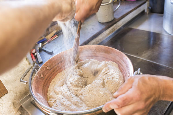 Chef preparing the typical polenta, San Romerio Alp, Brusio, Canton of Graubünden, Poschiavo valley, Switzerland