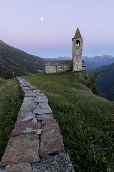 Ancient church at dusk, San Romerio Alp, Brusio, Canton of Graubünden, Poschiavo valley, Switzerland