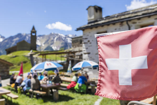 Swiss flag at the mountain retreat, San Romerio Alp, Brusio, Canton of Graubünden, Poschiavo valley, Switzerland