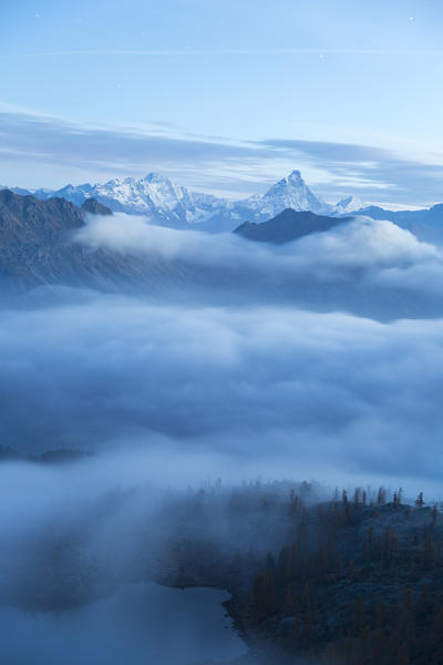 Fog covering the Aosta Valley in an autumn morning. The Matterhorn is emerging in the distant background with its massive colossus. Mont Avic natural park. Aosta Valley. Italy Europe