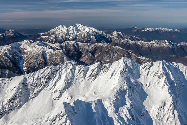 Flying high above the Orobie Alps after a heavy snowfall. In the background the two Grigne, in the foreground the peaks of Lesina valley Valtellina, Sondrio, Lombardy, Italy. Europe