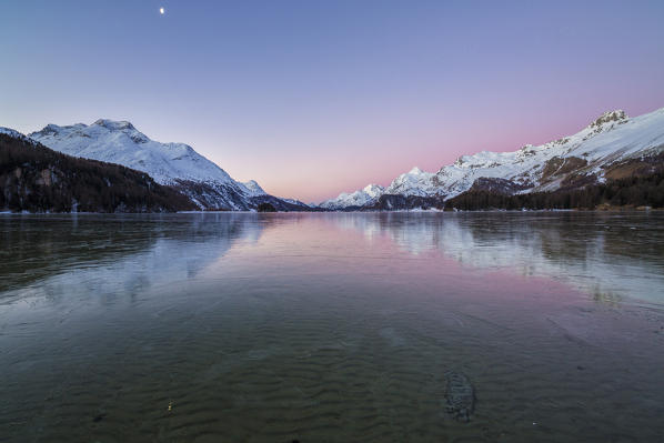 The snowy peaks are reflected at Lake Sils at dawn Upper Engadine Canton of Graubunden Switzerland 