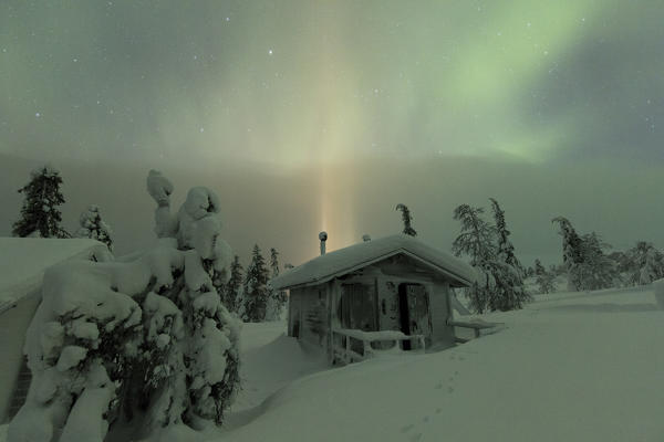 Northern lights on wood hut covered with snow, Pallas-Yllastunturi National Park, Muonio, Lapland, Finland